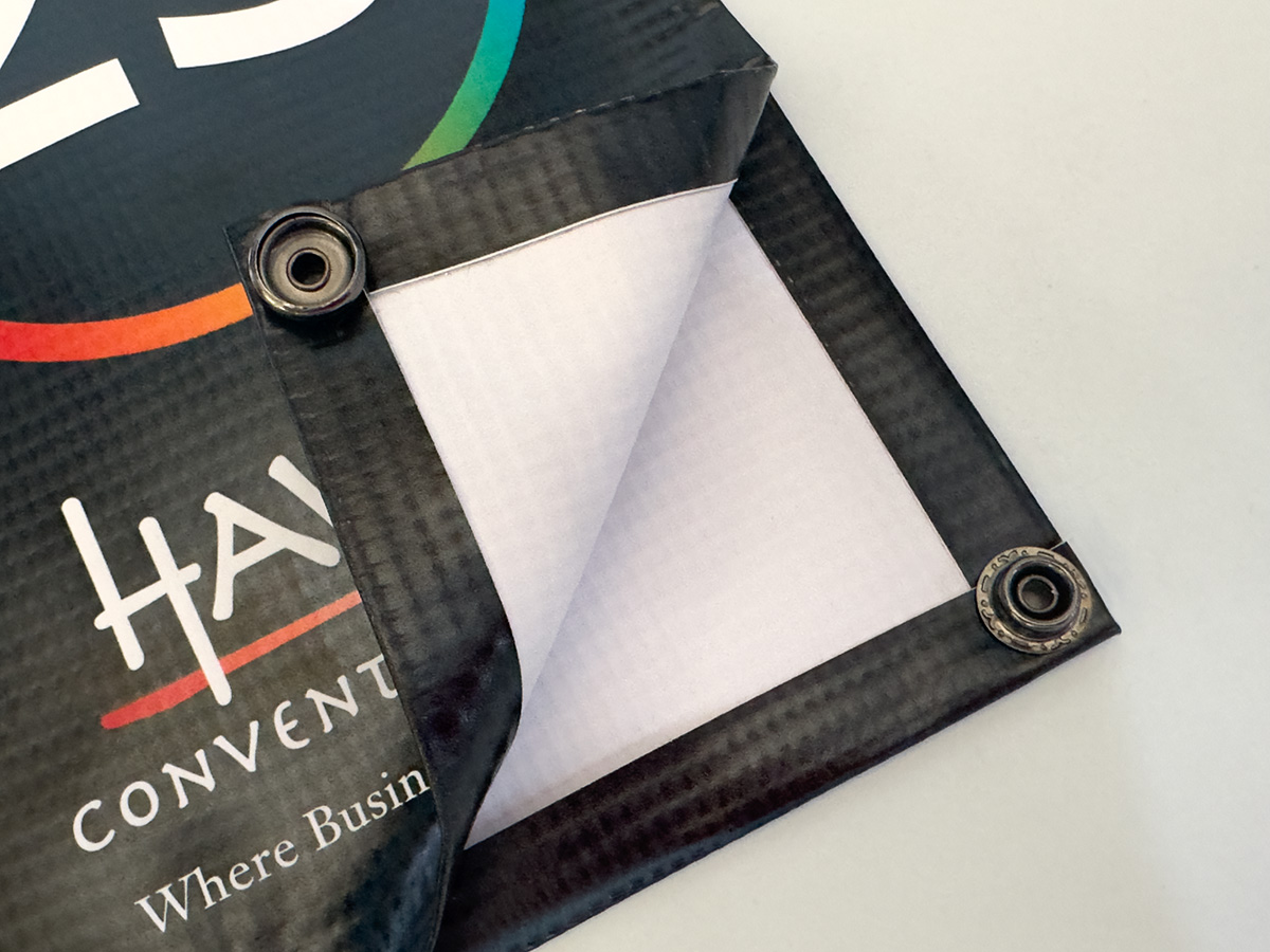 Close-up of NetSnapz snap fasteners pre-attached to the edge of a custom printed net banner