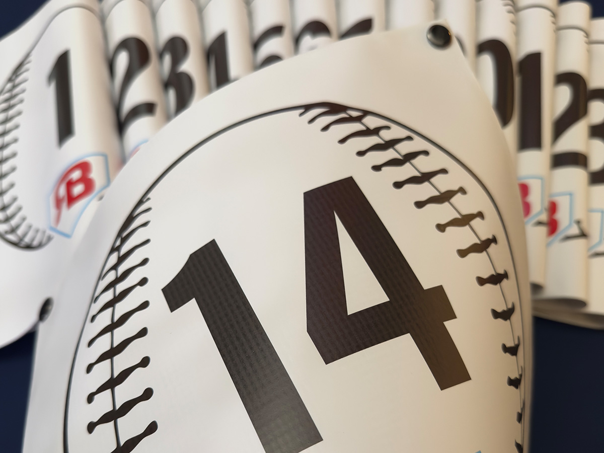 Bulk order of baseball field number snap-on banners printed in a baseball design, numbered and ready for tournament deployment